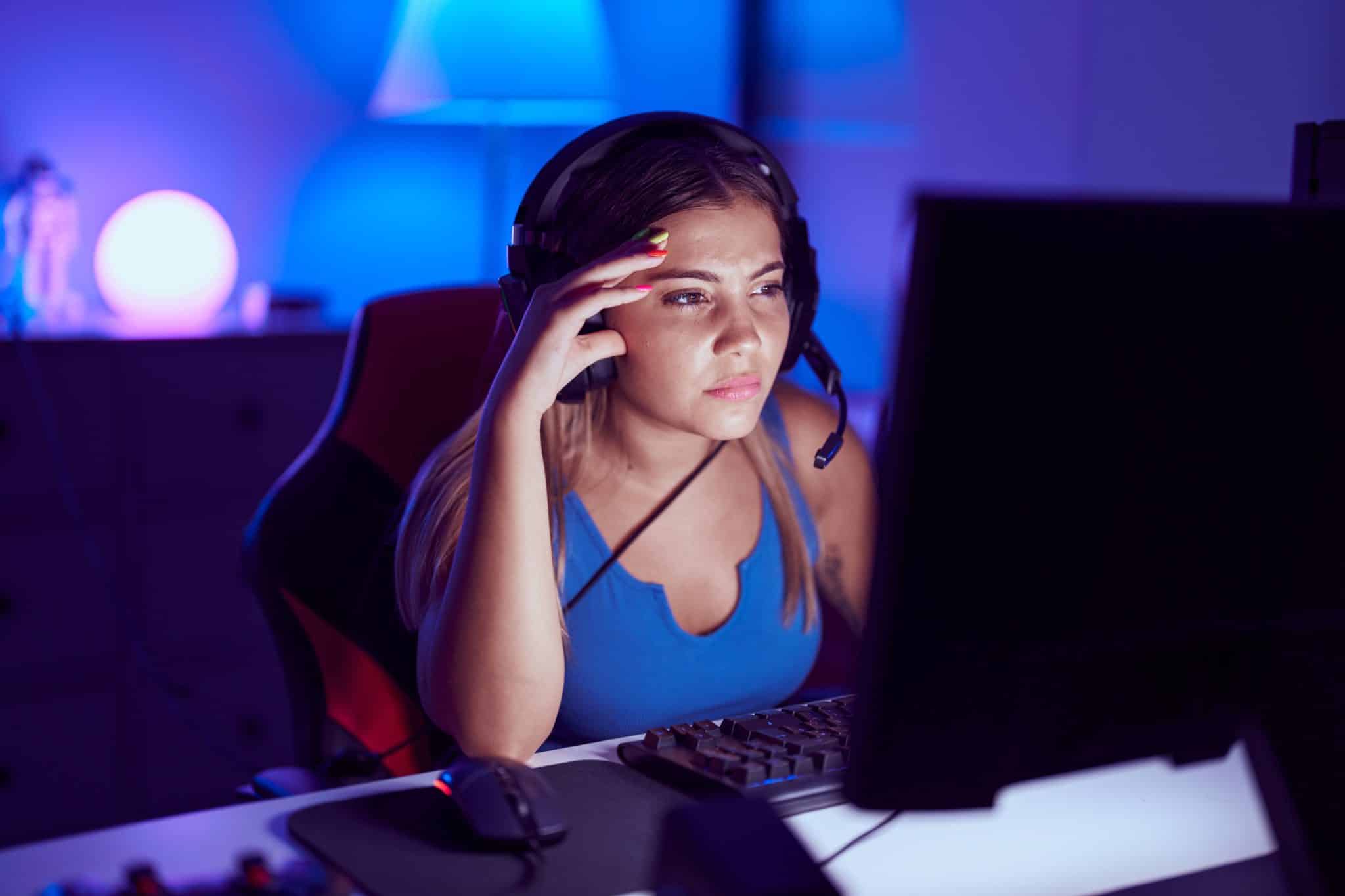 A teenager suffering from myopia squints at her screen, trying to see the images and text better by bringing her face closer to it.